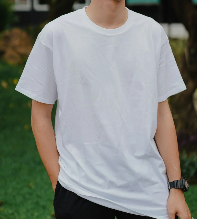 man in white crew neck t-shirt standing on green grass field during daytime